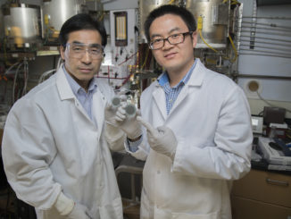 Professor Meilin Liu (links) und Yu Chen präsentieren im Labor eine mit dem Katalysator beschichtete Scheibe.