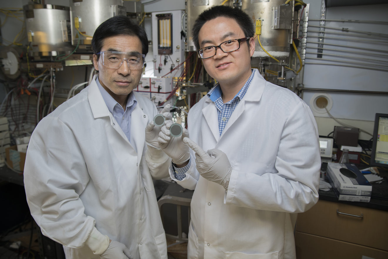 Professor Meilin Liu (links) und Yu Chen präsentieren im Labor eine mit dem Katalysator beschichtete Scheibe.