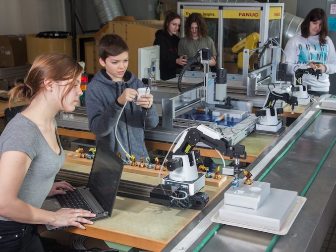 Leona (16) und Luis (14) arbeiten vorne an der Modell-Fertigungsstraße des TGM, einer echten Mini-Fabrik für Industrie 4.0. Hinten werken Paula, Jakob und Carmen, alle 14 Jahre alt. (c) TGM – Hetzmannseder